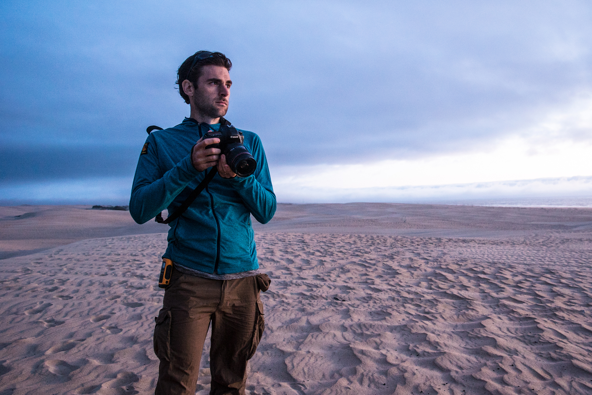 Ben Sherlock standing with camera in Australian desert